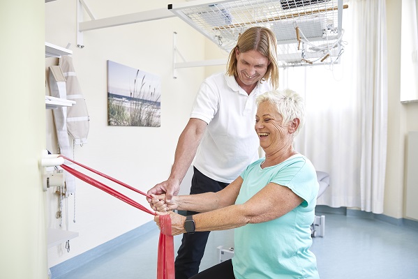 Patientin bei der Einzelkrankengymnastik mit einem engagierten Therapeuten. Patientin bei der Einzelkrankengymnastik mit einem engagierten Therapeuten.